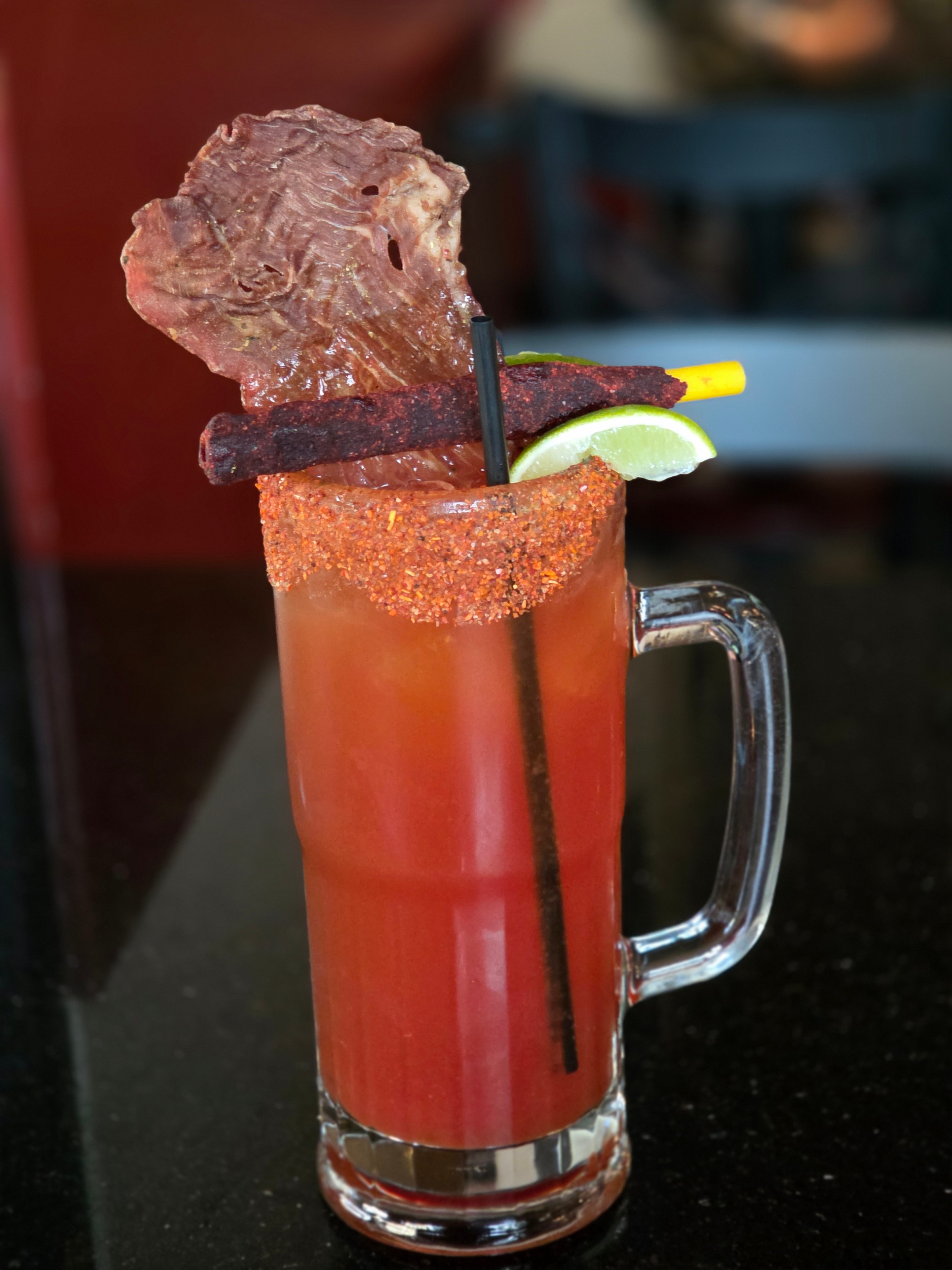 Carne seca garnishing a spicy cocktail with lime and chili rim